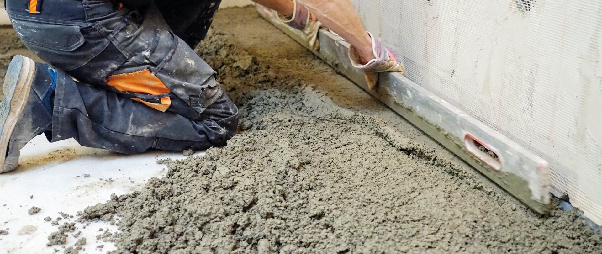 Lay cement screed and level it by hand using the leveling bar